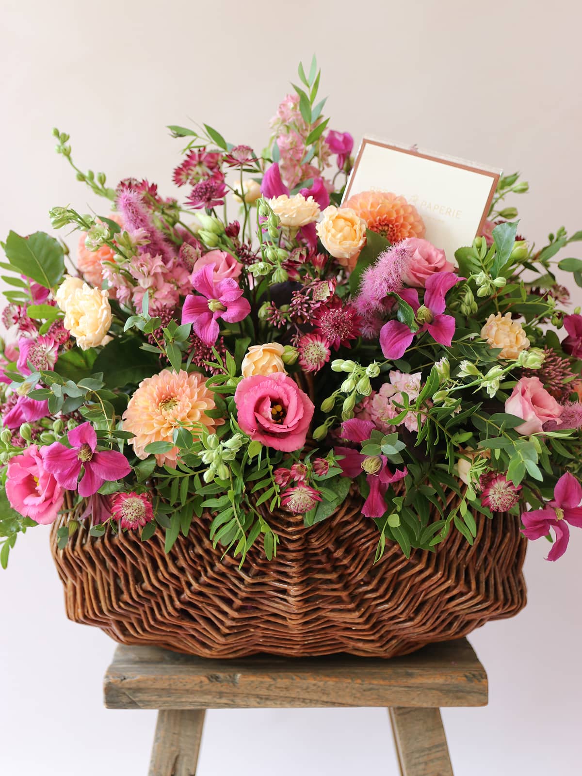 Bouquet of colorful flowers in a wicker basket on a white background