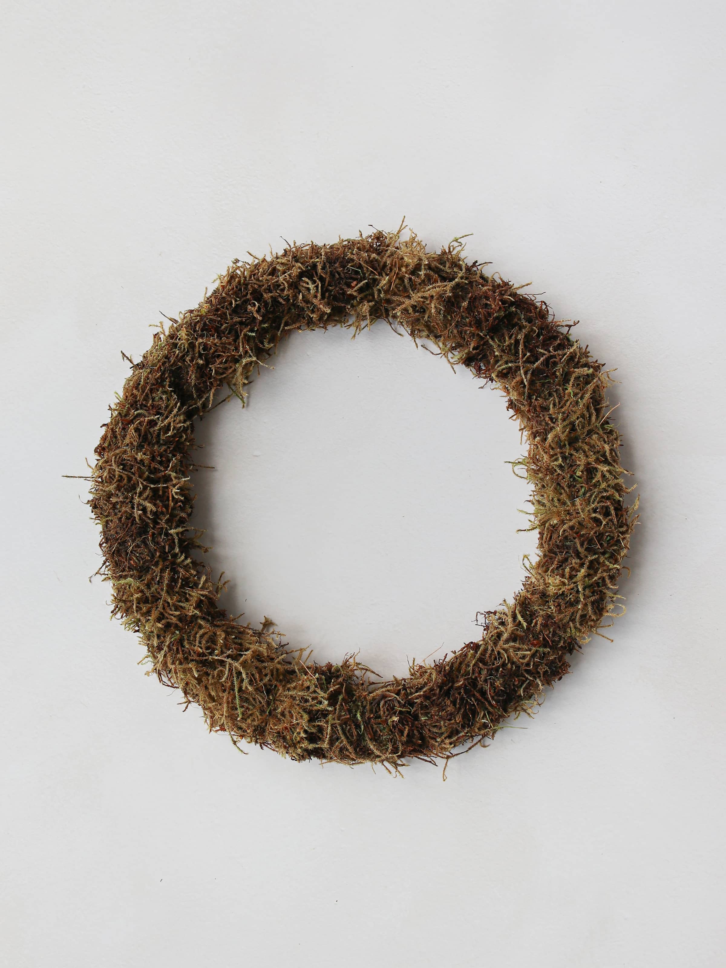 A mossed wreath base on a neutral background.