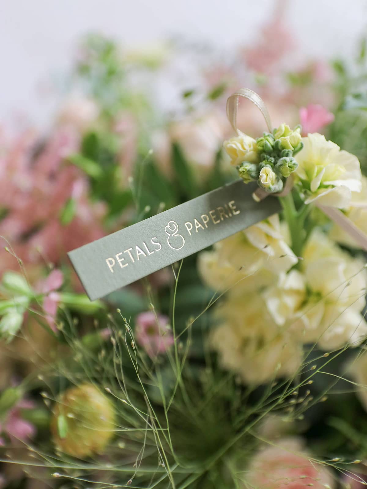 Bouquet of flowers with a 'Petals & Paperie' tag.
