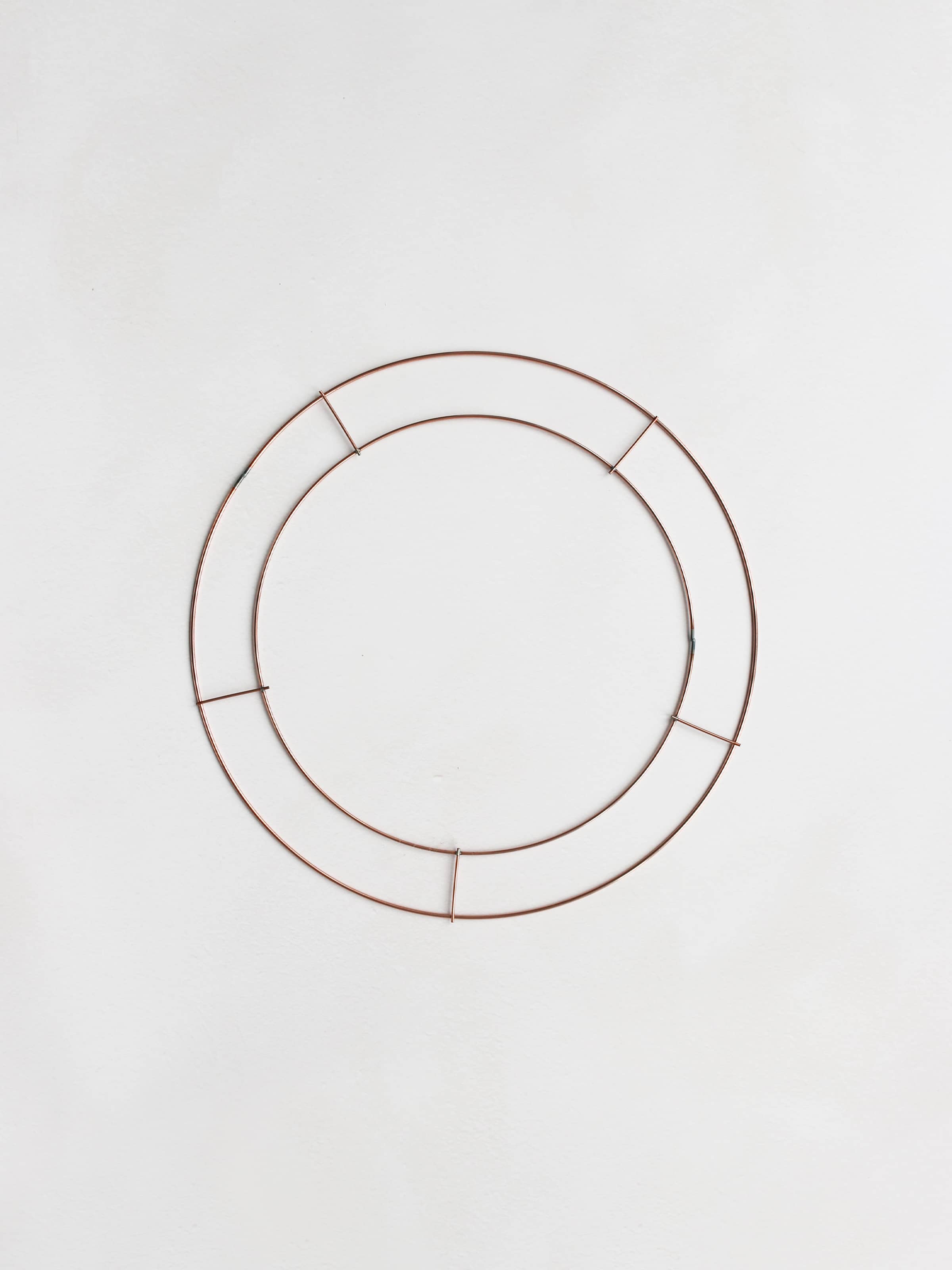 Copper wire wreath ring frame on a white background.