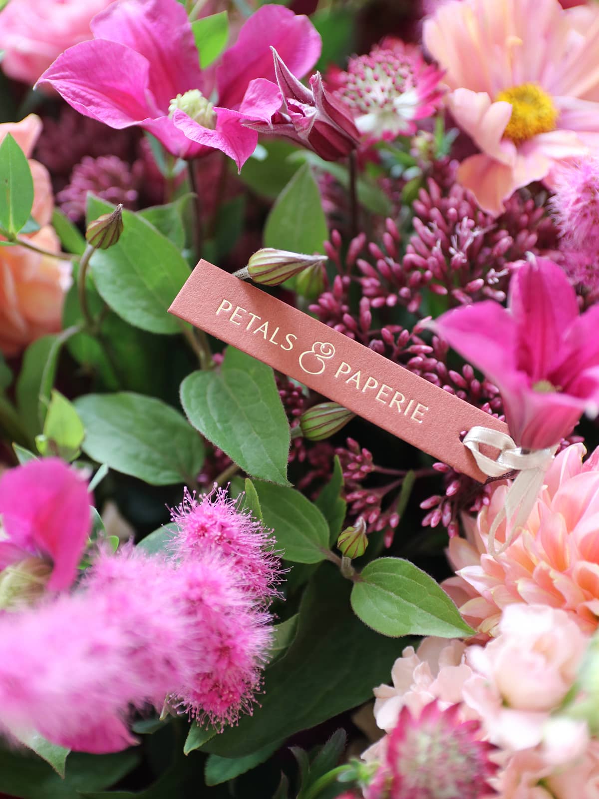 Pastels & Bright floral arrangement with a 'Petals & Paperie' tag