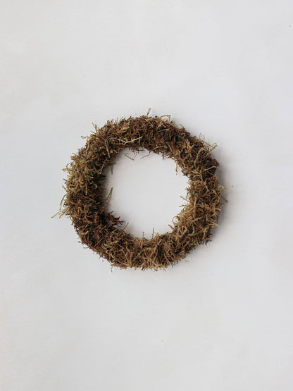 A small mossed wreath base on a neutral background.