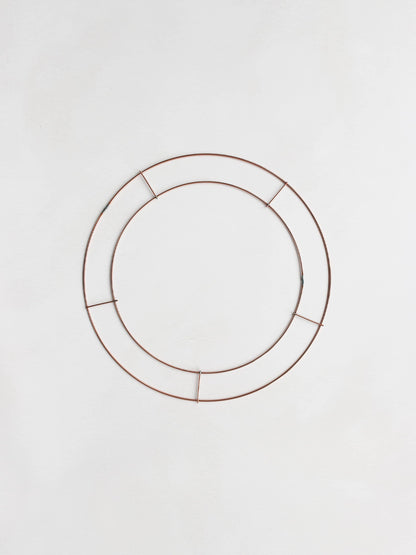 Copper wire wreath ring frame on a white background.