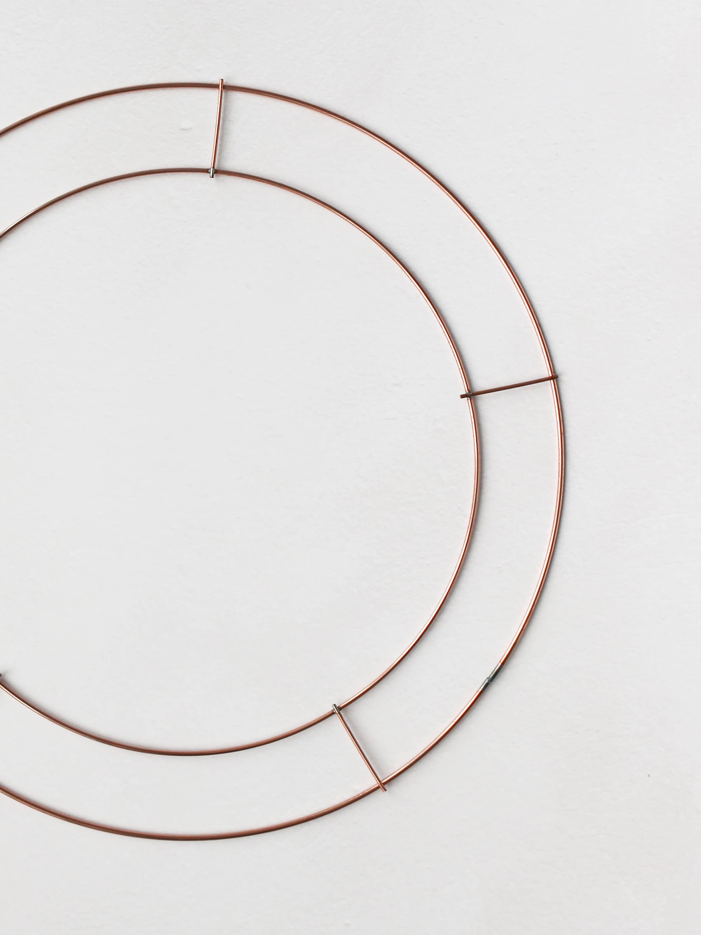 Copper wire wreath ring frame on a white background.