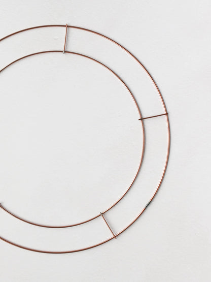 Copper wire wreath ring frame on a white background.