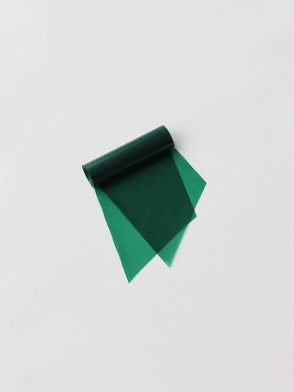 A roll of green wreath wrap, sitting on a neutral background.